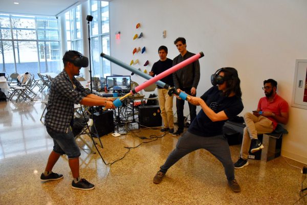 Students swordfighting in lab